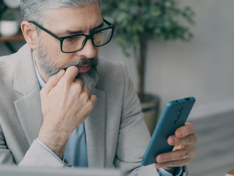 Mężczyzna telefon, sprawdzając cenę strony internetowej dla swojej firmy